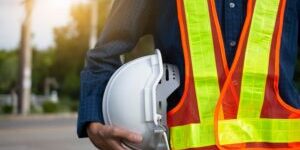 Engineering holds white safety hats and electric pole background